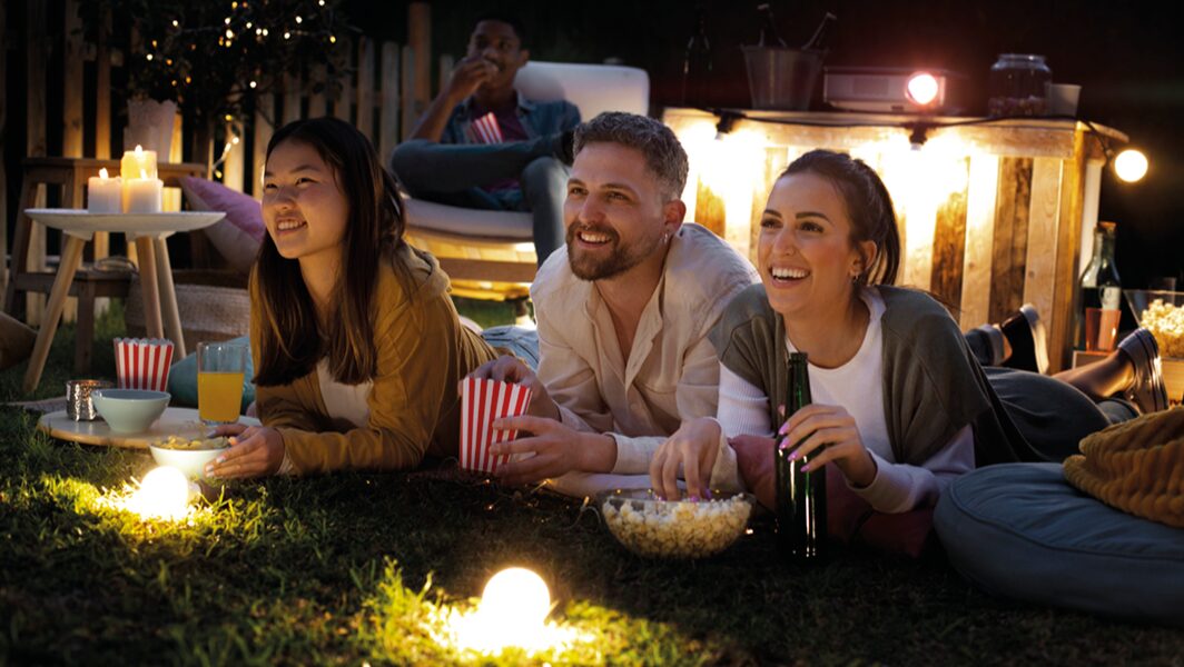 Tre ragazzi che guardano un film all'evento Cinema al giardino, a Marino