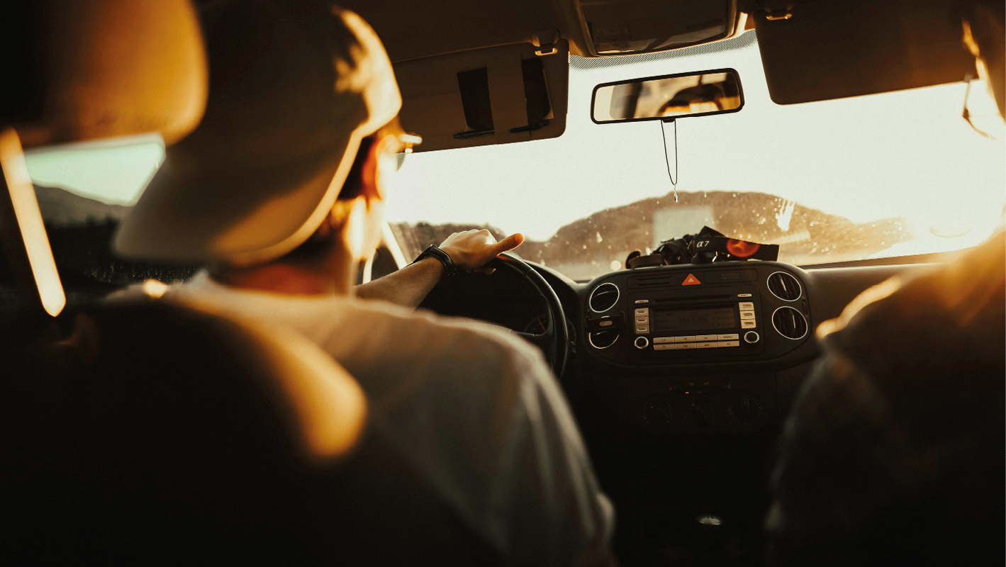 Ragazzo che guida un'automobile in un viaggio on the road