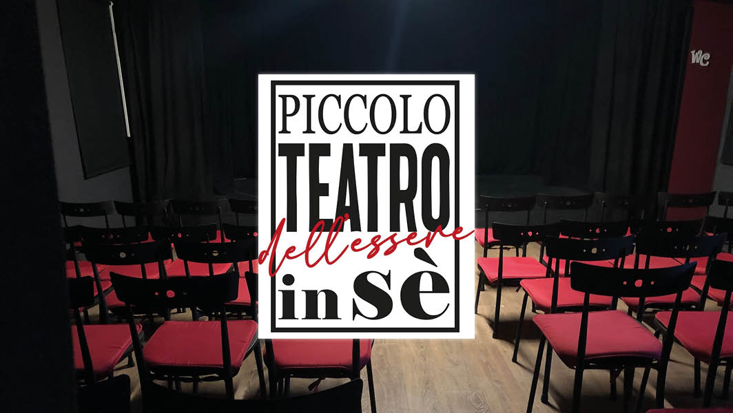 Interno del Piccolo Teatro dell'Essere in Sé a Ciampino, con file di sedie rosse e nere davanti a un palco.