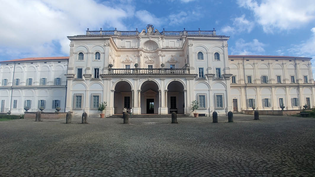 Facciata di Villa Falconieri a Frascati con cielo parzialmente nuvoloso sullo sfondo.