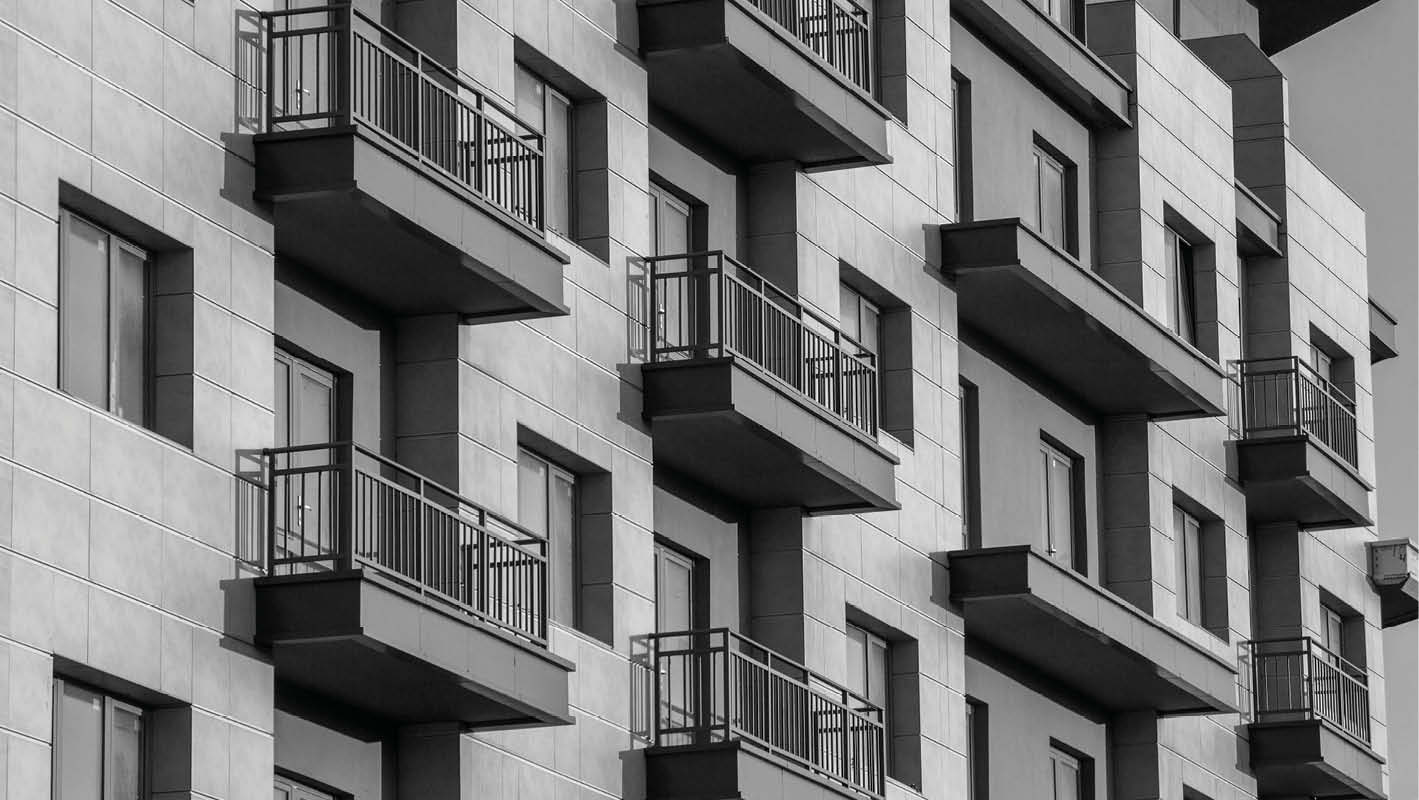 Facciata di un edificio residenziale moderno a Velletri con balconi e finestre, illuminata dalla luce del tramonto.