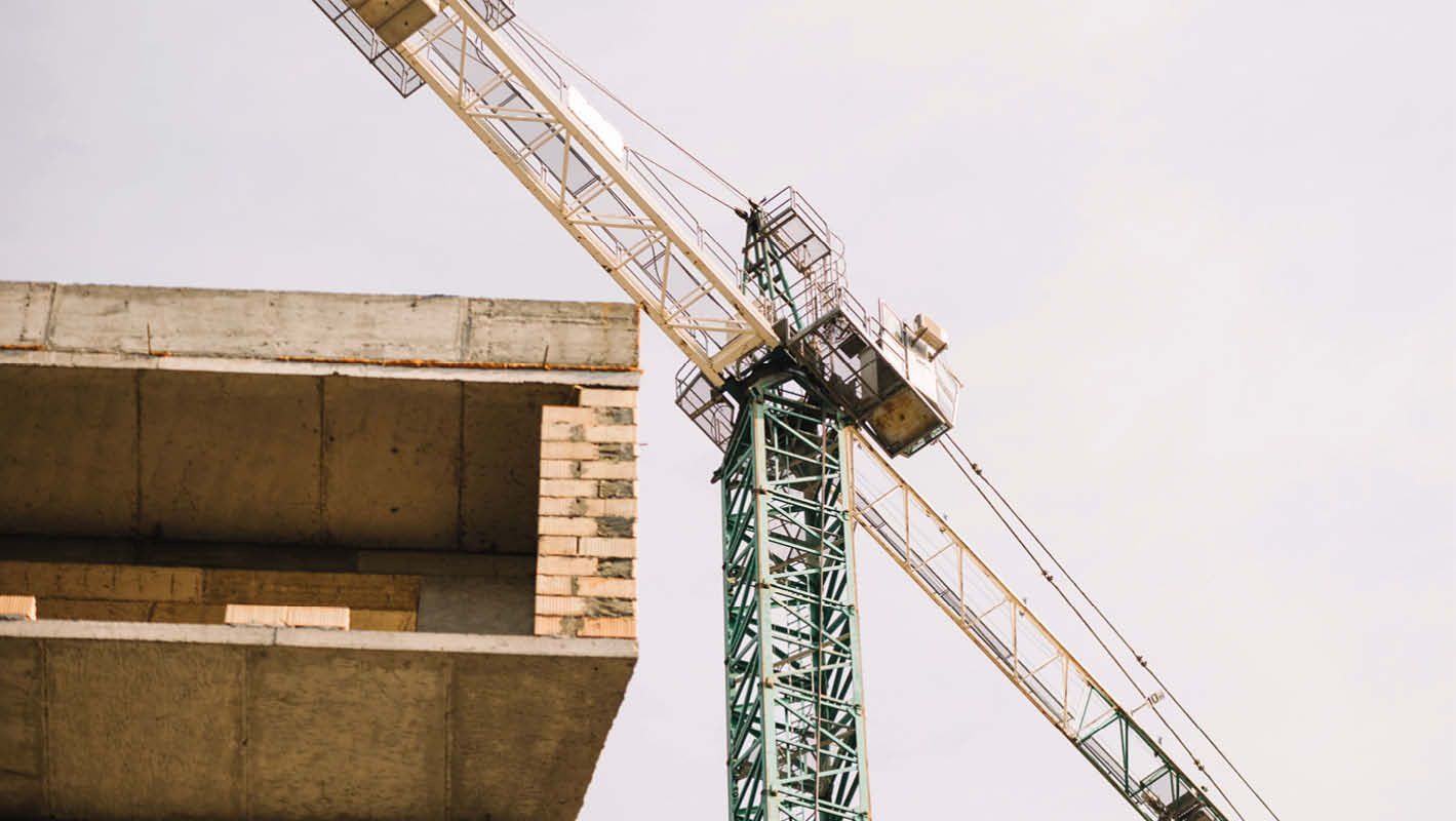 Cantiere edile incompiuto con gru in evidenza, visibile una struttura in cemento, simbolo del progetto urbanistico bloccato ad Ariccia.