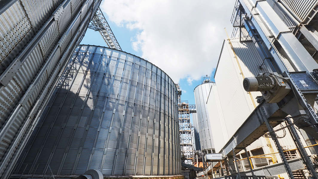 Vista di un impianto industriale di biometano a Velletri con grandi serbatoi cilindrici e strutture metalliche.