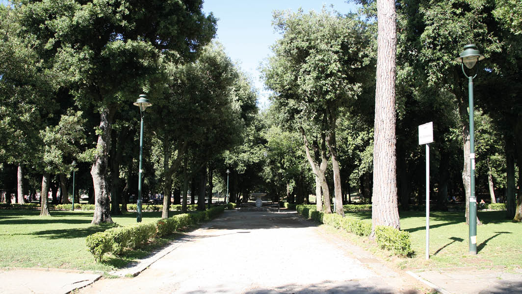 Viale alberato all'interno di Villa Torlonia a Frascati, con lampioni e siepi laterali.