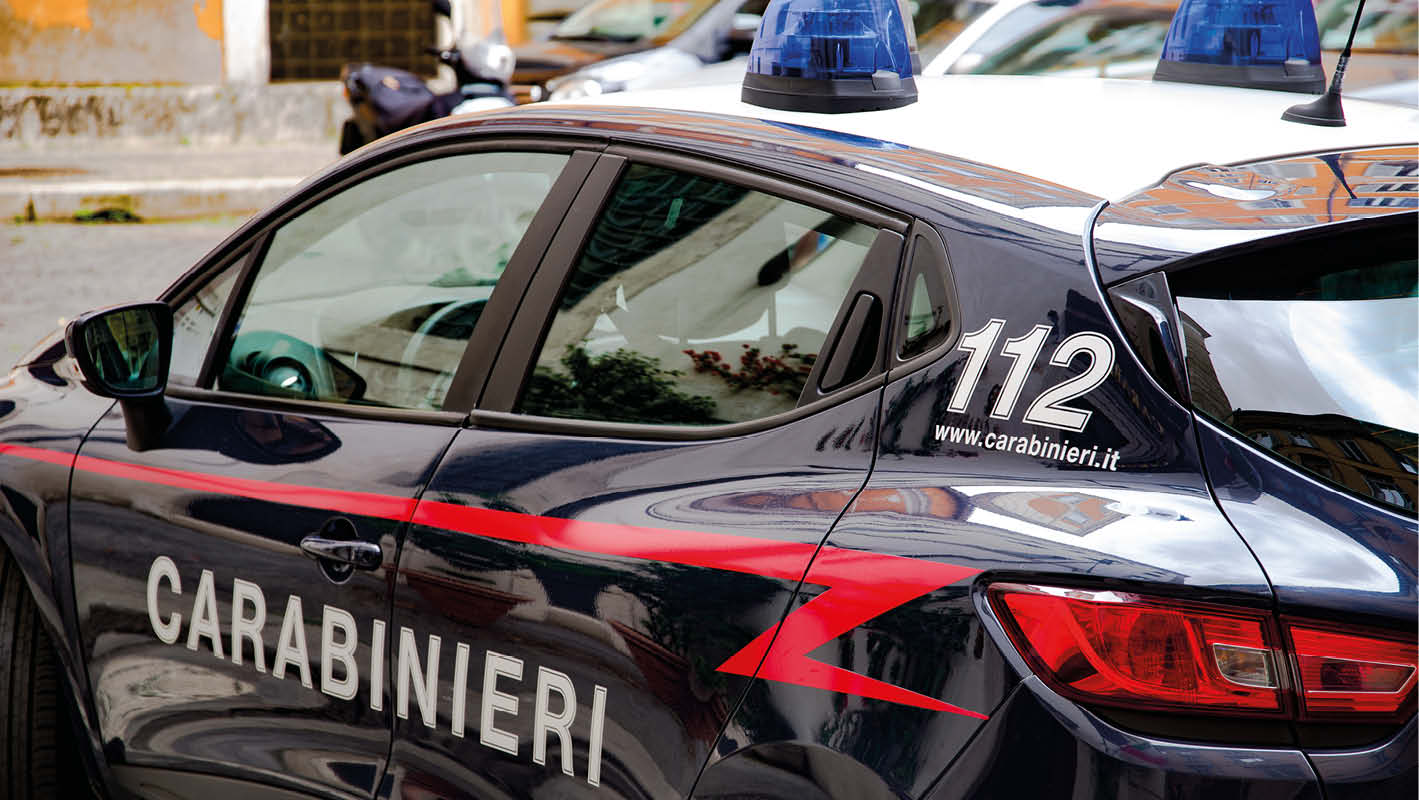 Auto dei Carabinieri parcheggiata in una strada di Roma, con il numero di emergenza 112 visibile sulla fiancata.