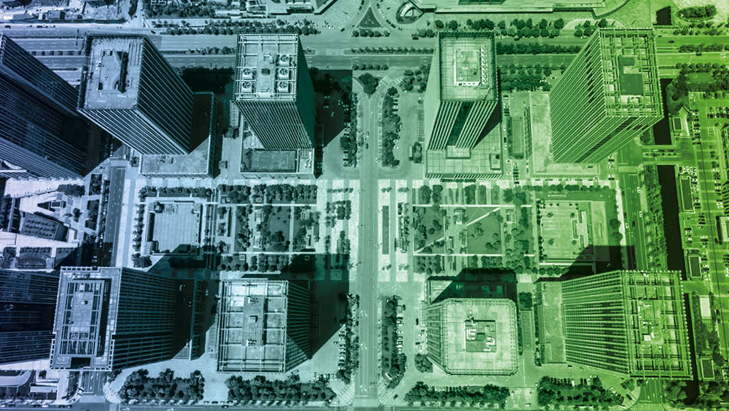 Veduta aerea di un complesso urbano con grattacieli e aree verdi, rappresentante una città moderna e sostenibile, in linea con i temi del convegno “Roma città in evoluzione” presso l’Università di Tor Vergata.