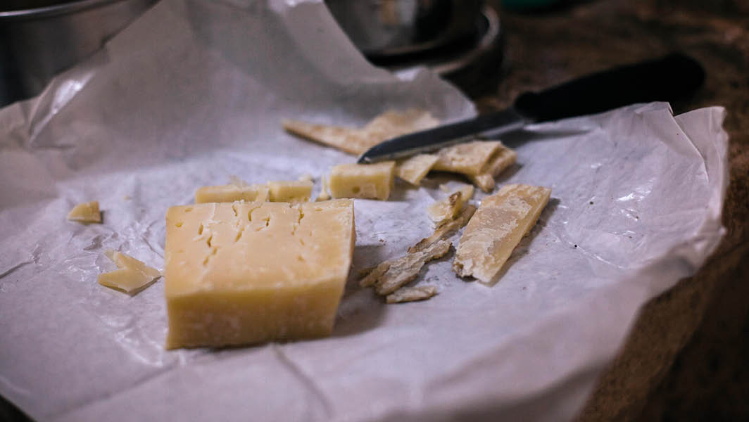 Formaggio stagionato su carta con coltello nero accanto, recuperato a Ciampino dopo un furto in supermercato