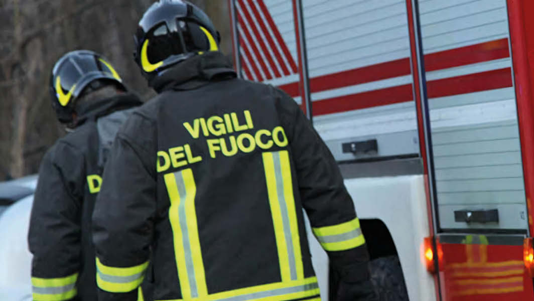 Vigili del fuoco a Genzano di Roma in servizio accanto a un mezzo antincendio durante un evento pubblico.