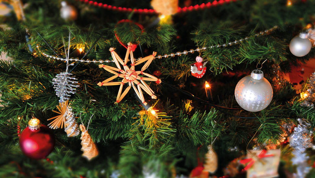 Decorazioni natalizie a Lanuvio su un albero di Natale, con ornamenti in legno, sfere argentate e luci calde.