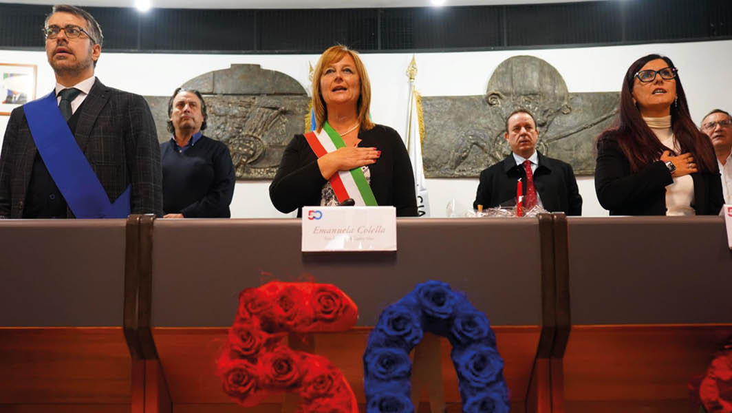 La sindaca Emanuela Colella e altre autorità locali durante la cerimonia per il 50° anniversario di Ciampino come Comune autonomo, con decorazioni commemorative sul tavolo.