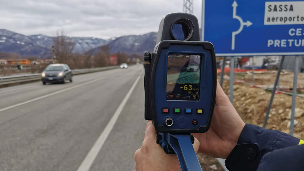 Dispositivo di autovelox mobile della Polizia Stradale in funzione su una strada nel Lazio, con veicoli in transito e cartelli stradali visibili sullo sfondo.