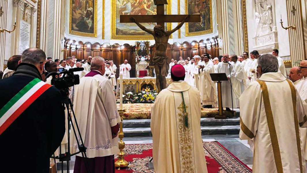 Celebranti e fedeli nella Cattedrale di San Pancrazio ad Albano Laziale durante l’apertura del Giubileo 2025, con al centro una grande croce lignea.