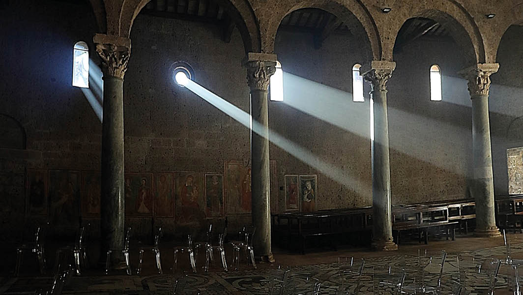 Raggi di luce naturale illuminano l'interno della Basilica di Sant’Elia, rendendolo il luogo perfetto per eventi culturali come il concerto narrato de La Terzina all'interno del Sol Invictus.