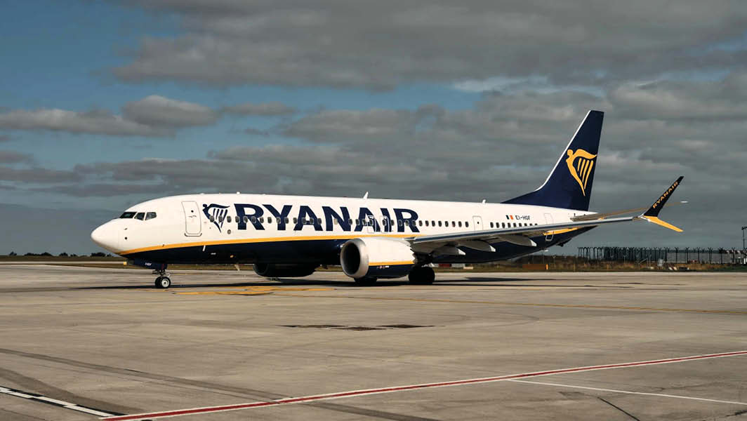 Aereo Ryanair sulla pista dell'aeroporto di Ciampino con cielo nuvoloso sullo sfondo.