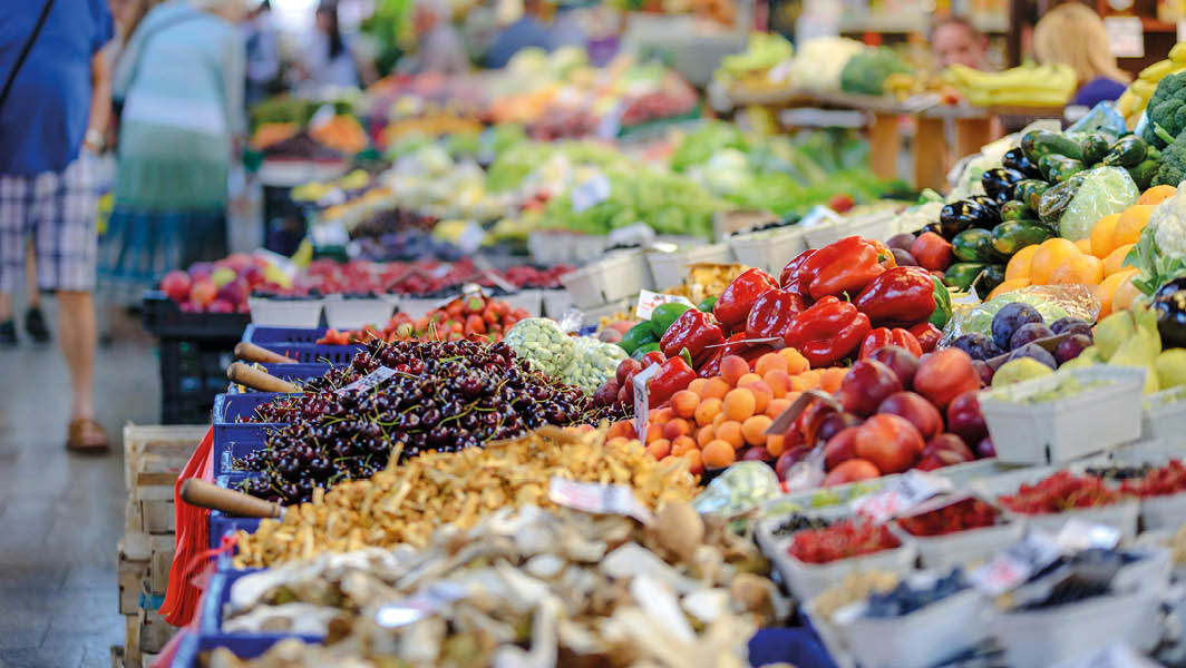 Banco di frutta e verdura fresca al mercato, con colori vivaci che rappresentano prodotti locali, simboleggiante l'iniziativa di Lanuvio