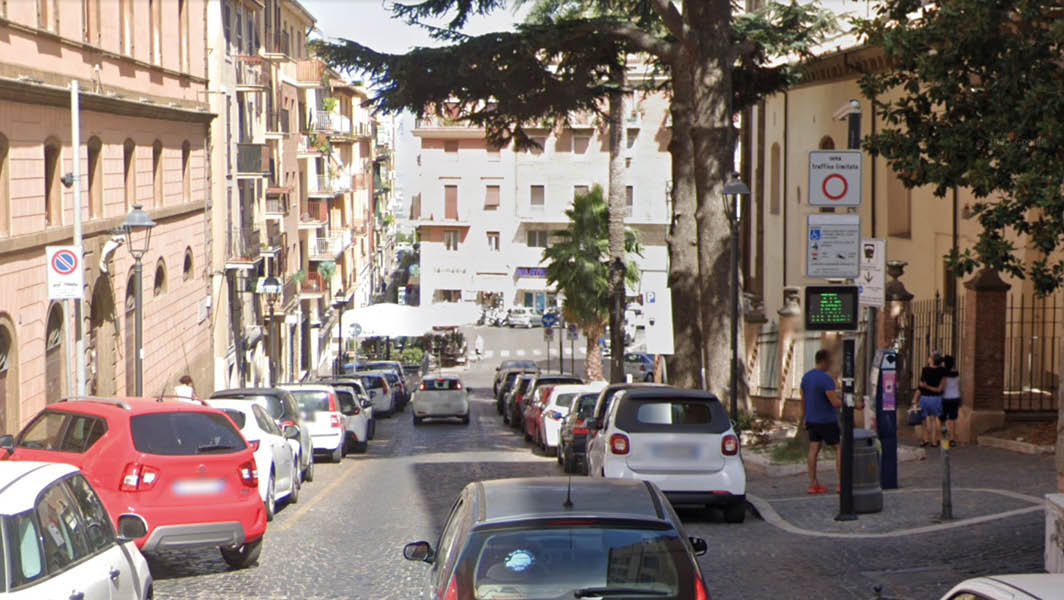 Corso Italia a Frascati, con auto parcheggiate lungo i lati e un cartello che segnala l’ingresso nella Zona a Traffico Limitato.